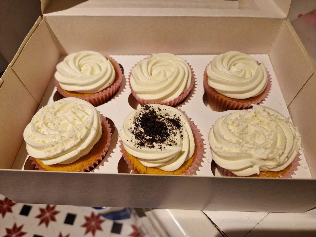 A box of six vanilla and cookies-and-cream cupcakes with swirled buttercream, by Kakes by Grace